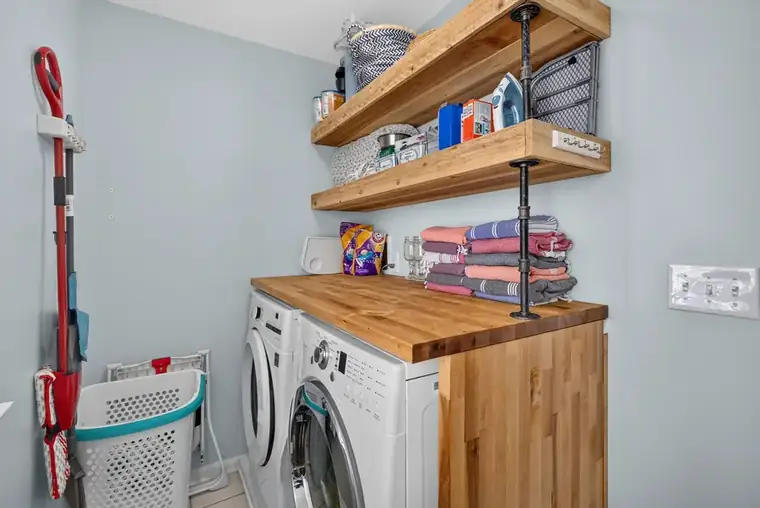 Laundry room with full-size washer and dryer and folding counter